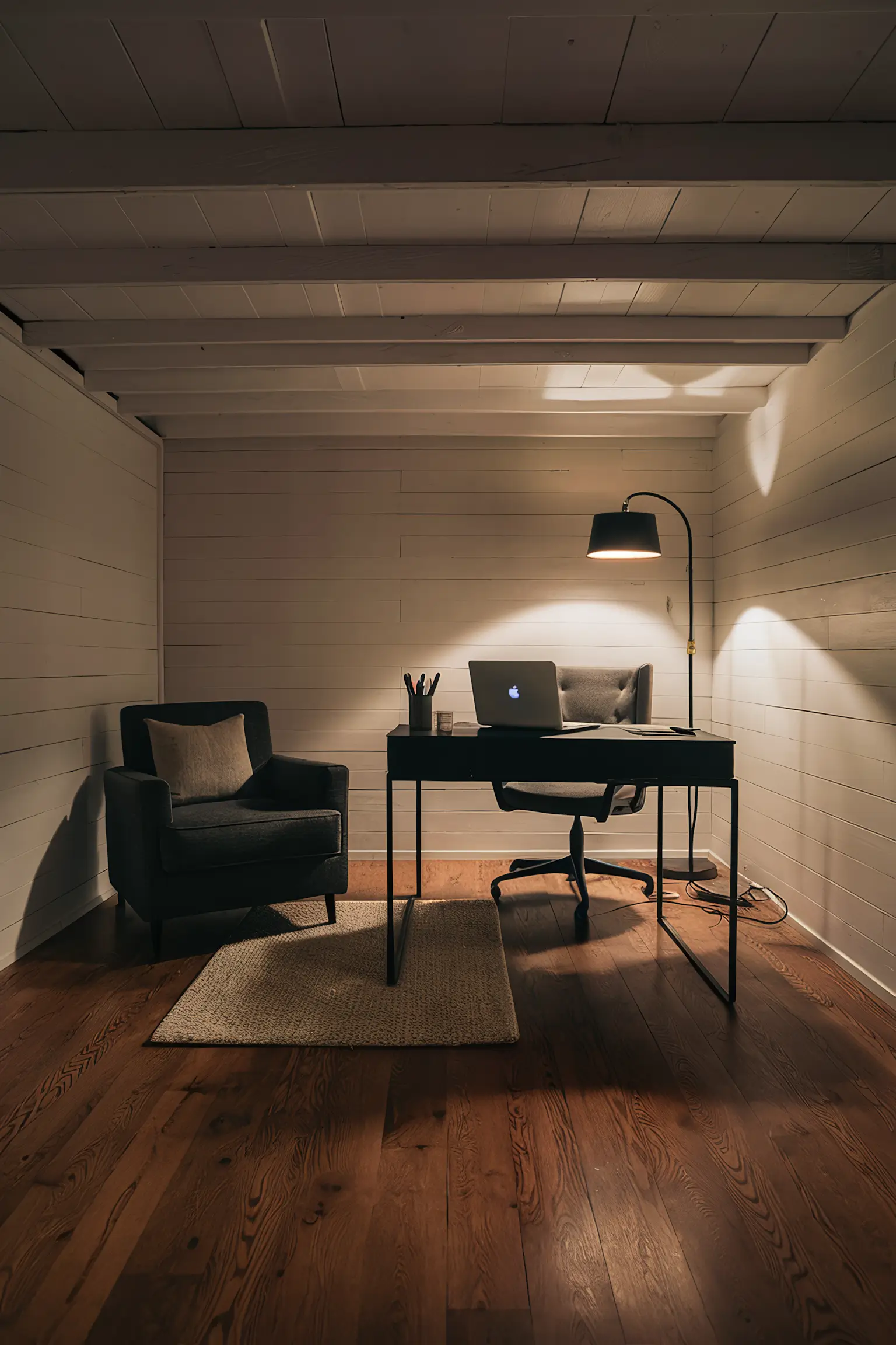 Minimalistic basement office with hardwood flooring.