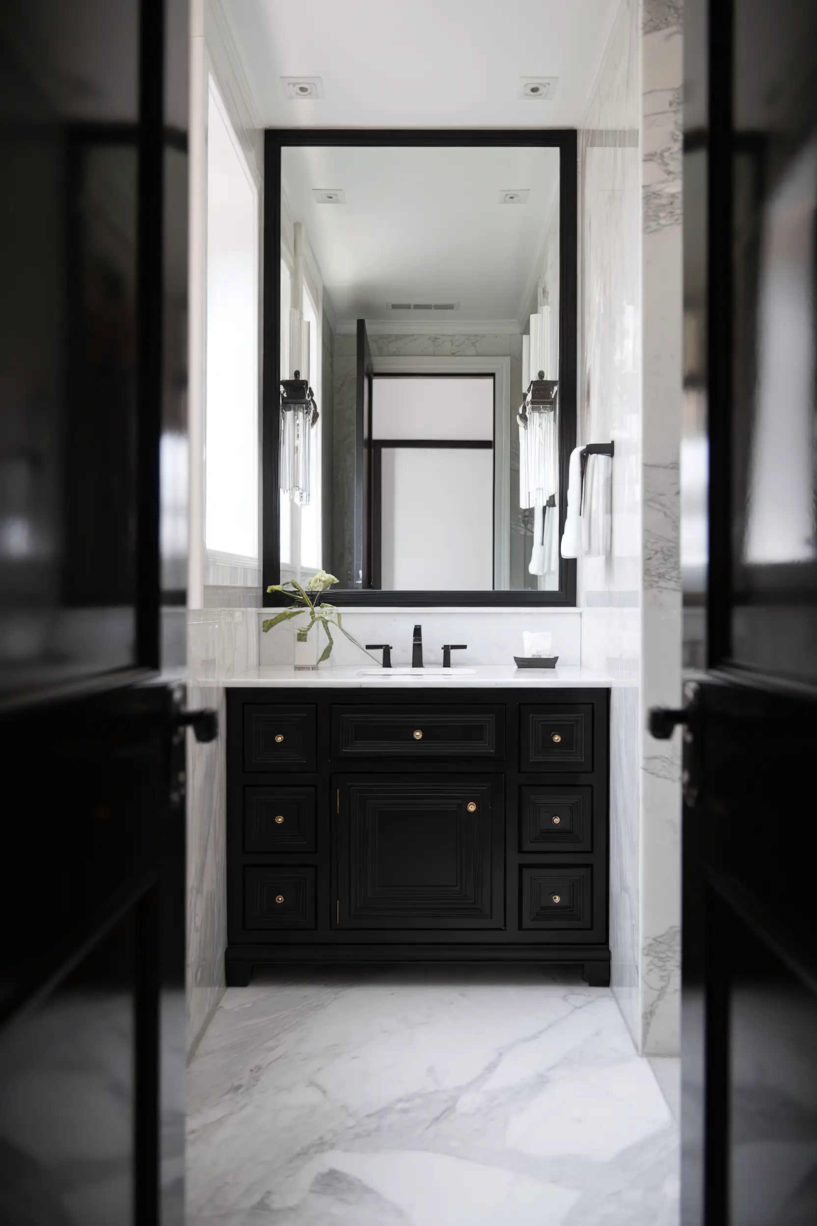 Black and white small luxury bathroom with bold black fixtures and white marble surfaces.