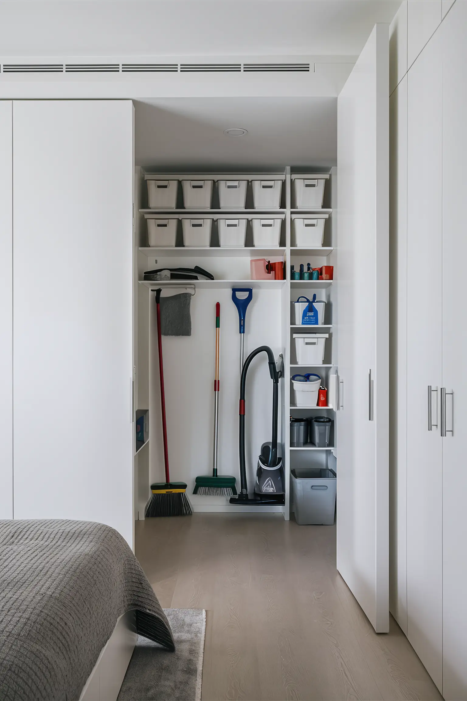 Bedroom closet with a dedicated cleaning section and storage bins.